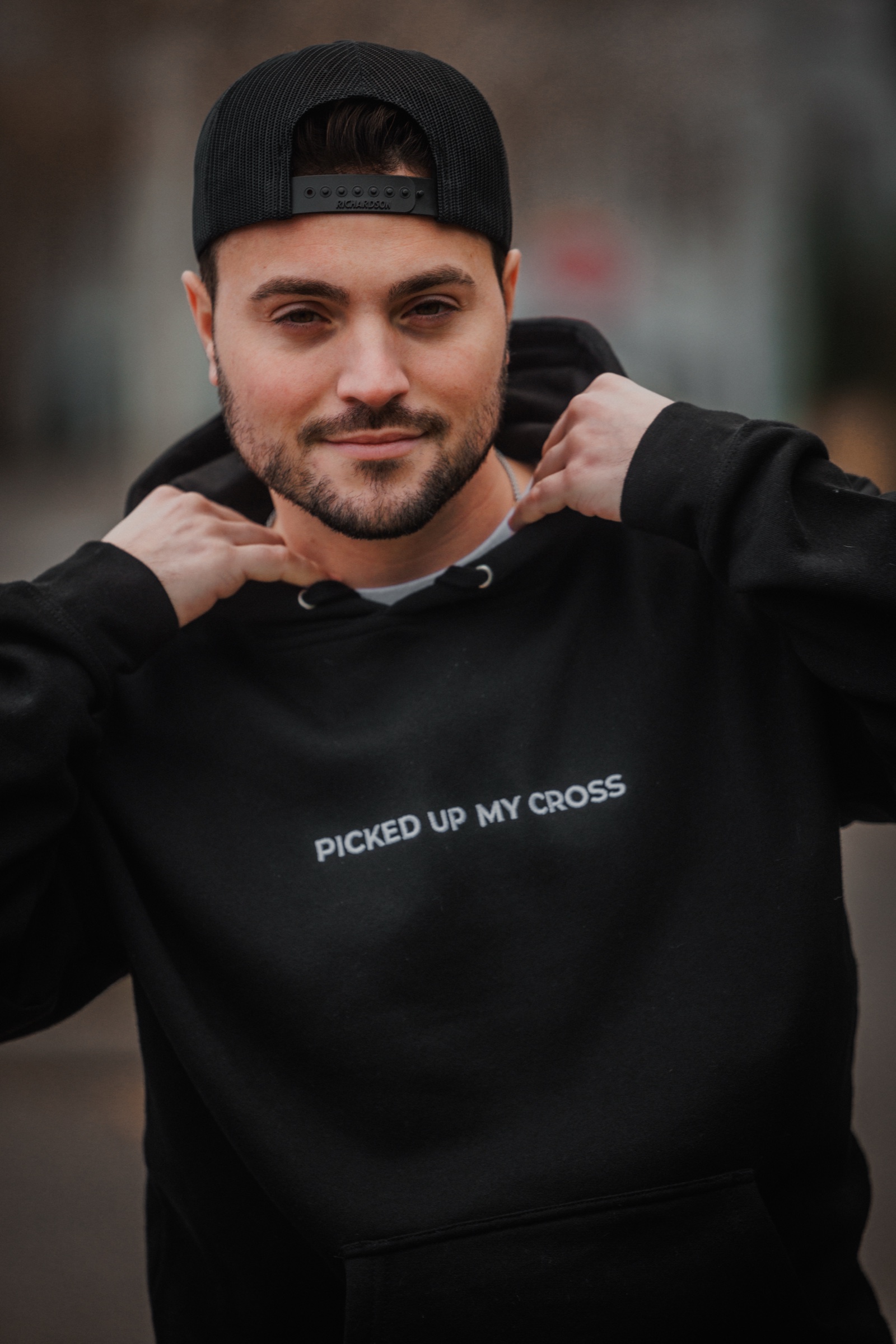 Portrait wearing the black Picked Up My Cross hoodie